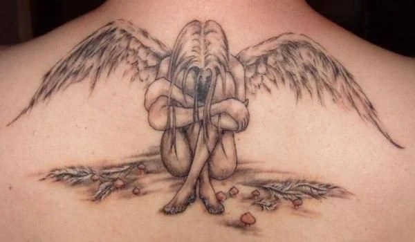 vemos tatuaje de un ángel de la guarda, es un tatuaje realista en tonos grises