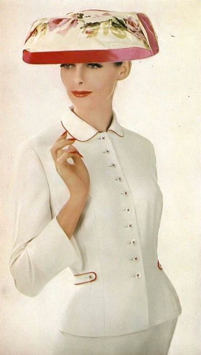 Model Anne St.  Marie wearing white suit and flowered hat in Lillian Bassman photo for Harper's Bazaar