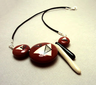 collier de créateur avec galets de céramique rouge à graphismes noir et blanc