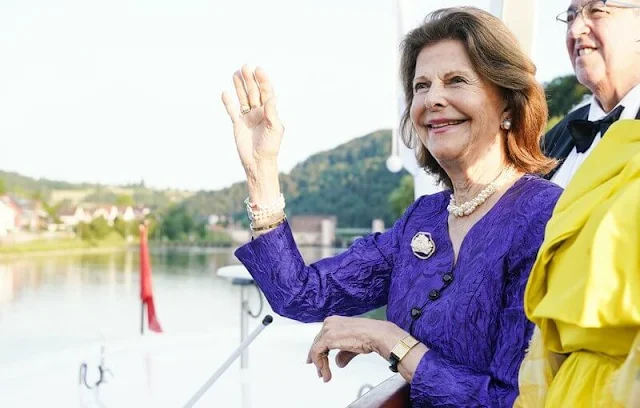 Queen Silvia wore a royal blue jacket and black trousers. Gold bracelet and gold diamond earrings flower brooch