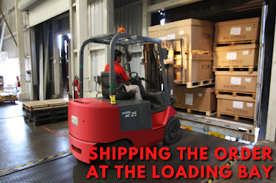 Worker loading the packed cargo in the truck to be shipped using a forklift