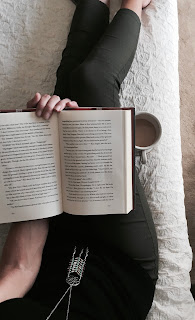 A person sitting down with a book and coffee