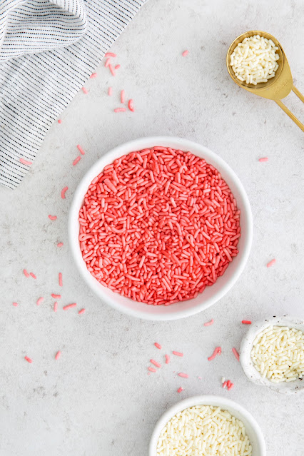 pink sprinkles in a white bowl with gray background.