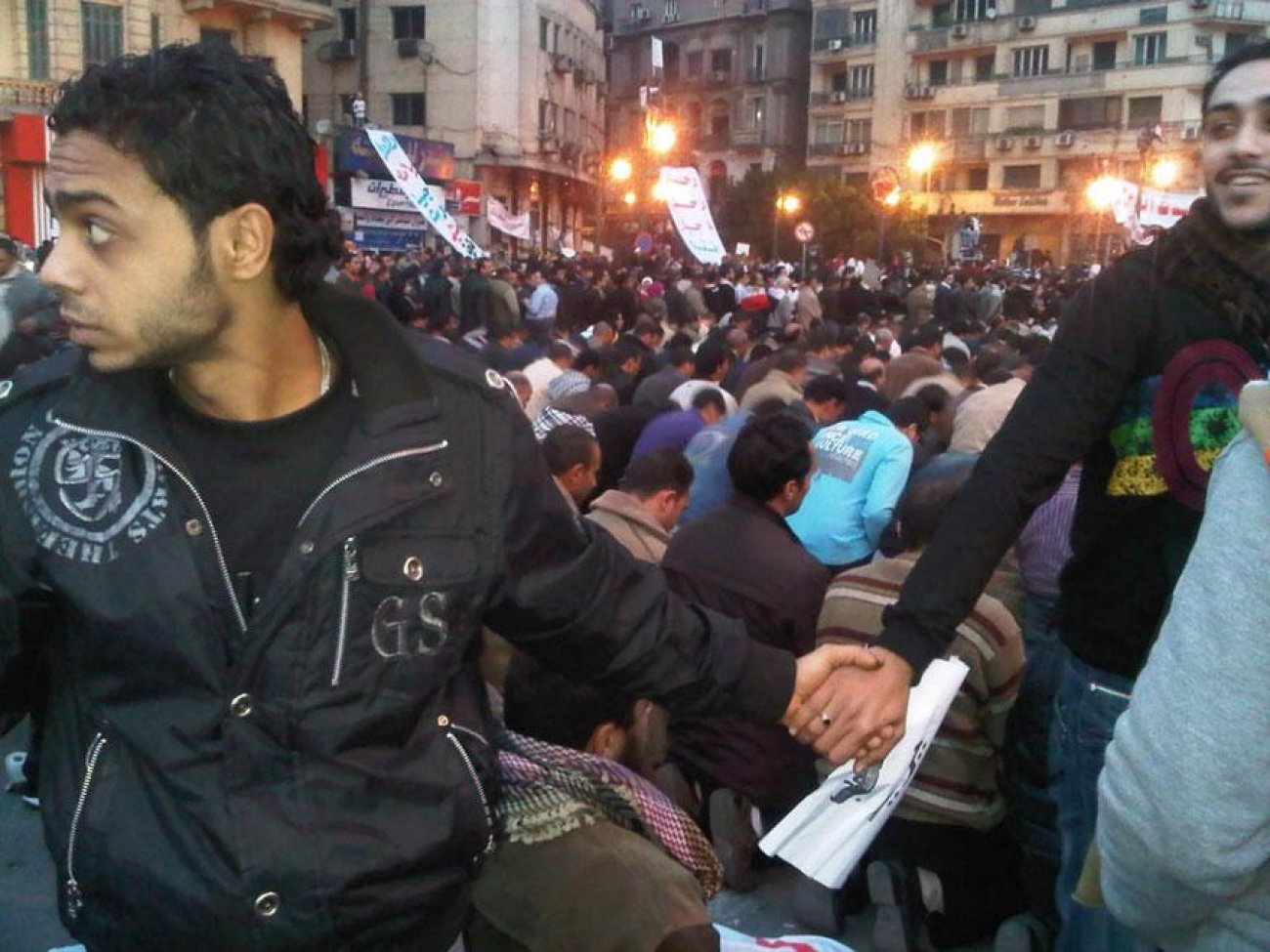 February 2011, Egypt Christians join hands to protect Muslims as they pray during Cairo protests.