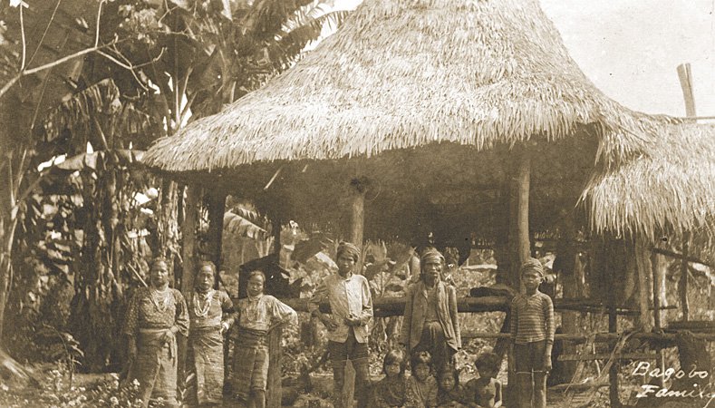 Bagobo family in front of a house structure, early 20th century