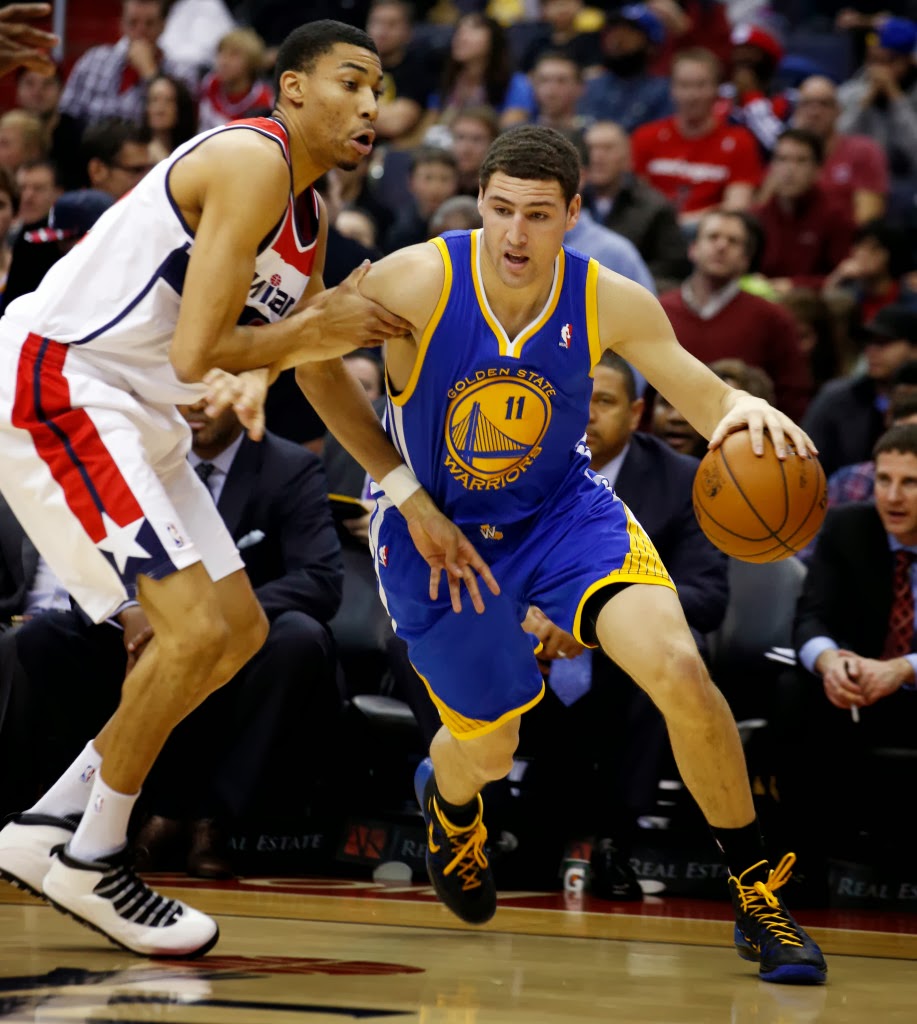 Golden State Warriors guard Klay Thompson (11) gets past Washington Wizards forward Otto Porter Jr. (22) in the first half of an NBA basketball game on Sunday, Jan. 5, 2014, in Washington. (AP Photo/Alex Brandon)