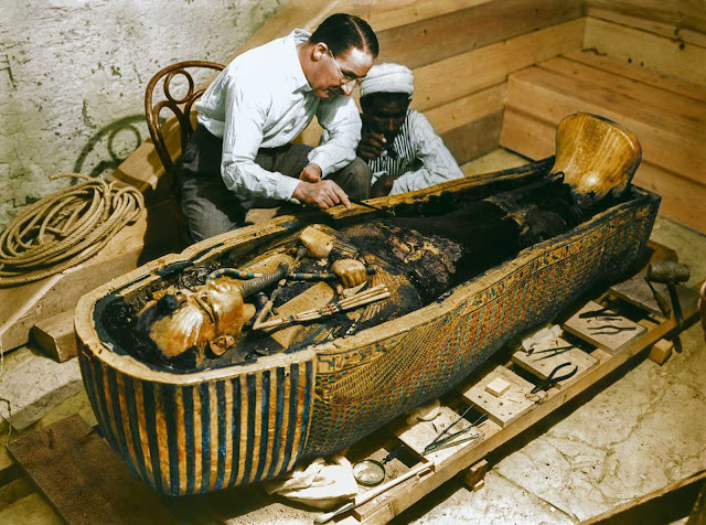 Carter and a worker examine the solid gold innermost sarcophagus.