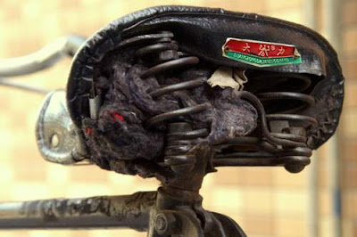 Image of a bicycle seat losing its stuffing, in China, seat manufactured by Suong Zong Dalian Zuo Chang.