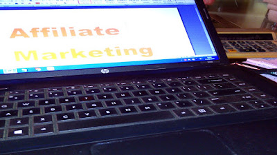 Affiliate marketing business work station with a computer, calculator and notepads.