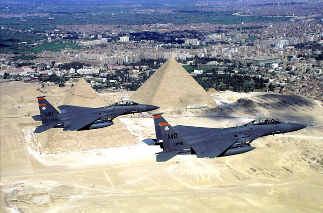 A pair of F-15E Strike Eagles, fly over the pyramids.