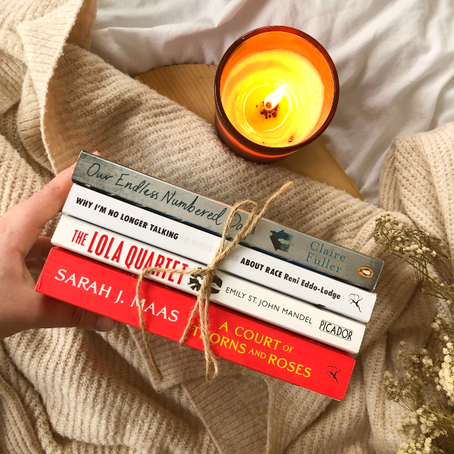 Book stack wrapped in string next to a candle