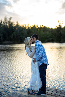 couple kissing on dock at lake