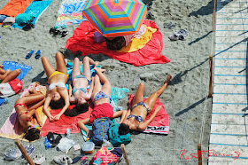 Five young women sunbaking on the beach at Monterosso Al Mare, Cinque Terre, Italy. Photographed by Kent Johnson for Street Fashion Sydney.
