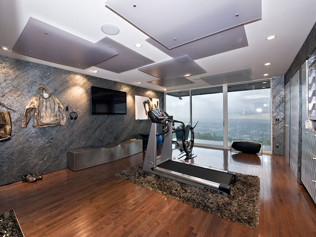 Picture of large room with flat tv on the wall and an exercising machine