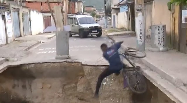 Ciclista cai em cratera durante reportagem ao vivo e surpreende repórter ao xingar prefeito de Mesquita, no RJ