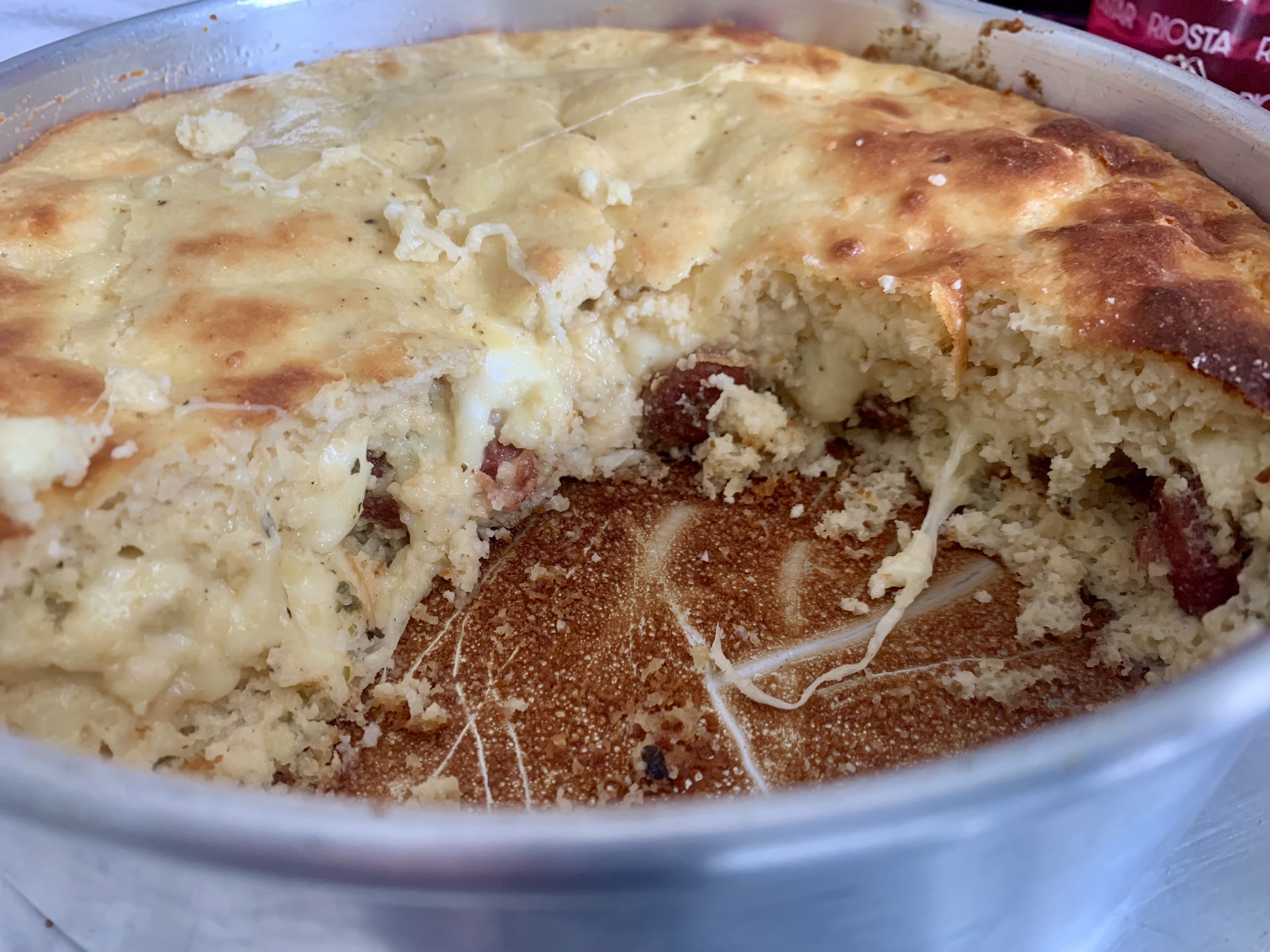 Torta Low Carb de Linguiça Suína com Farinha de Amêndoas e Iogurte Natural cortada dentro do tabuleiro de alumínio