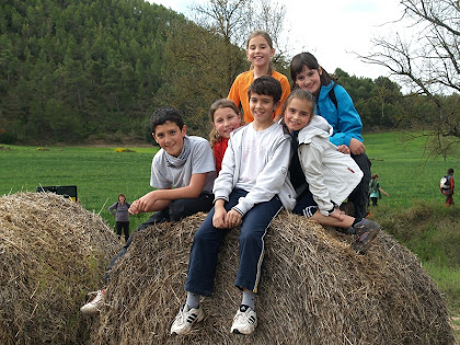 Joves caminaires enfilats a les bales de palla d'El Graner