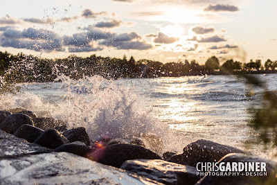 view of waves frozen with a high shutter speed, and backlit by a setting sun