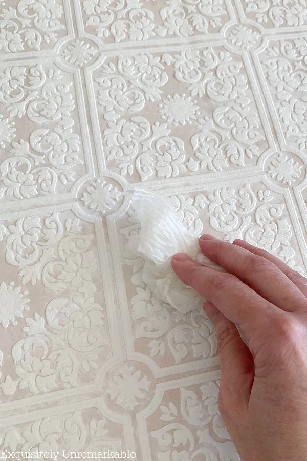 How To Apply Paintable Wallpaper hand wiping water away from paper