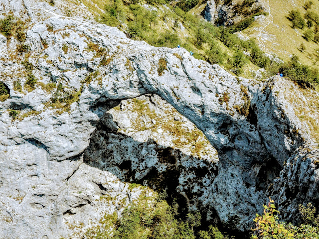 Due escursionisti impegnati a transitare sull'estradosso dell'arco