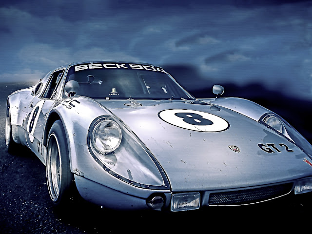 Image of a grey Porsche 904 race car against a cloudy blue sky. Image by George Cosmos Wagner