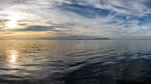 Photo of the sun going down over the Solway Firth with the Scottish hills in the distance