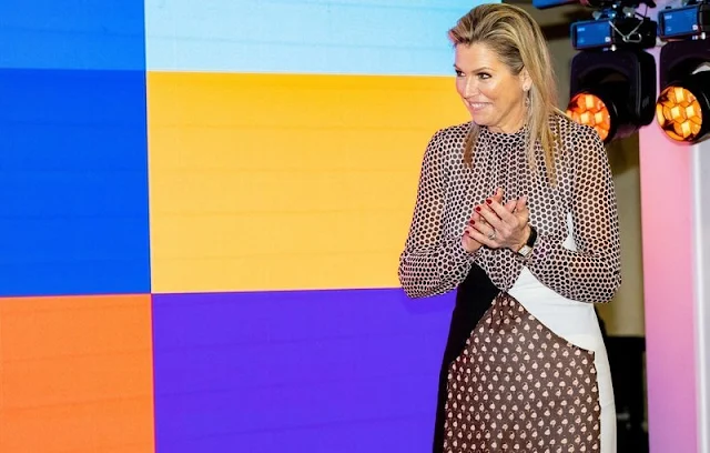 Queen Maxima wore a polka-dot paneled silk dress by Giambattista Valli.  Black wool cape abd lavender earrings