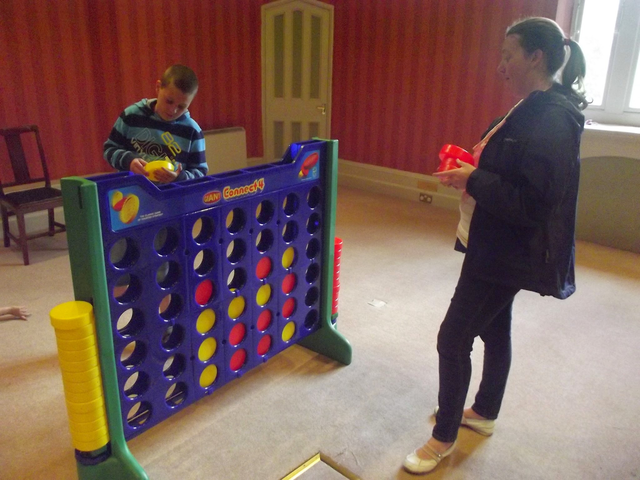 boy and woman playing connect 4