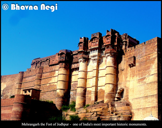 Mehrangarh Fort, Jodhpur, Rajasthan is one of the largest and colossal fort of India. Located atop a 150m elevated hill and enclosed by imposing thick walls. Inside its boundaries there are several palaces known for their intricate carvings and expansive courtyards.The fort was built by Rao Jodha, when he transferred his capital from Madore to Jodhpur. And with every ruler(s) of Jodhpur came subsequent additions to this captivating piece of architecture.The fort has seven famous gates and each one significant for its own mention in history. The famous of all and most important being Jai Pol (meaning Victory), the first gate when you enter, was built by Maharaja Man Singh after his victory on Jaipur and Bikaner.Another gate, Fateh Pol(also meaning victory) was raised by Maharaja Ajit Singh to laud the defeats of Mughals.Also, as you enter, you see the prominent mark of canon balls on the Dedh Kamgra Pol, another famous gate of the fort.You shall never miss the palm imprints smeared in vermillion on the gate, that leads to the funeral pyre - that has reminiscence of the commitment and self-immolation of princesses and queenAnd the chhatri of 'Kirat Singh Soda'- testify the valor and fearlessness of this great soldier who died while guarding against Amber armies. [I was so rapt in listening that I missed taking the pictureAs you take a tour of the fort you come across an elaborate palace of balconies, arched galleries, and heavily ornamented private residences, and seemingly miles of strategically twisty, misleading passageways and stairs and decorated rooms - each one with its own significance and few now - exhibiting the royal palanquins, miniature paintings, furniture, and historic armory and et cetera.The entire fort overlooks a prawling desert city lined with the vivid blue-painted houses of Brahmins, India's priestly caste.[Isn't that about prevailing caste systemAnyways, since the color 'Blue' is associated with royalty and power - the Brahmins took to coloring their houses blue to signify their domicile and to set them apart from the rest of the population. And eventually take respect.[Till date, the people of Jodhpur have maintained this tradition.]I may fall short of words and  for the sake of not spending the entire day captioning these images, I will simply let the photos themselves tell the story of my visit. Mehrangarh is one of India's most important historic monuments.. it is the center of religious pilgrimage of scholarly study and of heritage conservation. and it is a magnet for visitors from the surrounding.  And I shall not end this photo journey without mentioning that, the famous hollywood blockbuster movie 'The Dark Knight Rises' has shot a prison scene at Mehrangarh fort.