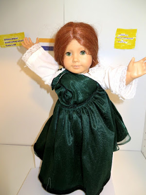 American Girl doll in white nightgown with green velveteen dress draped across one shoulder in imitation of ancient Roman robes