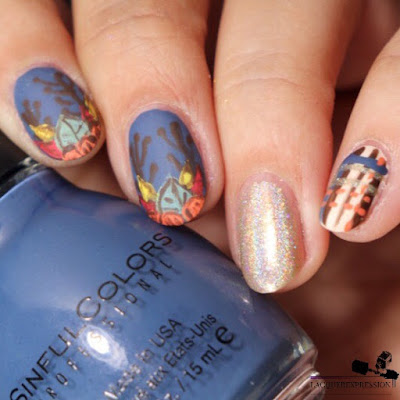 hand painted nail art design with fall leaves and pumpkin over a blue background for Thanksgiving