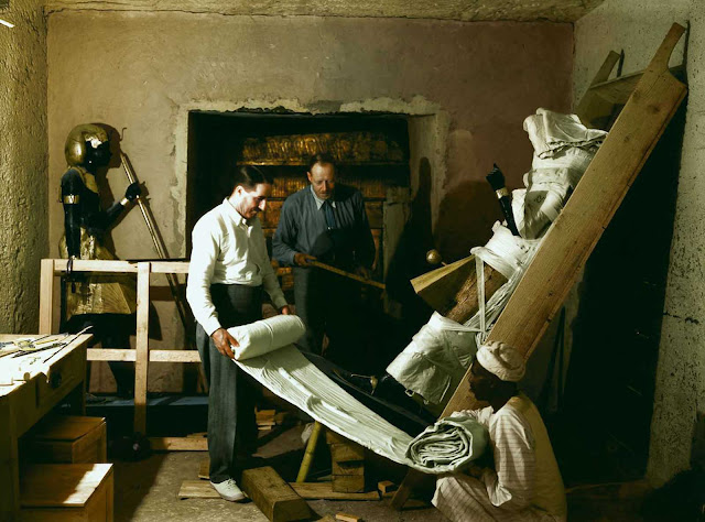 Howard Carter, Arthur Callender and an Egyptian worker wrap one of the sentinel statues for transport.