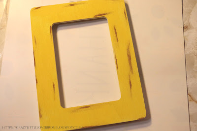 Yellow painted picture frame with brown paint thinly rubbed in sections