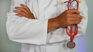 a doctor in a white coat holding a stethoscope