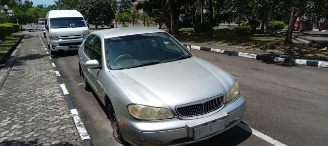 Mobil Merk Cefiro Plat Merah Tidak Terawat Diparkirkan di Halaman Parkir DPRD Batam