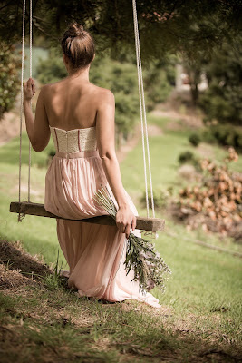 Dama de honor sentada en un columpio colgado de un árbol