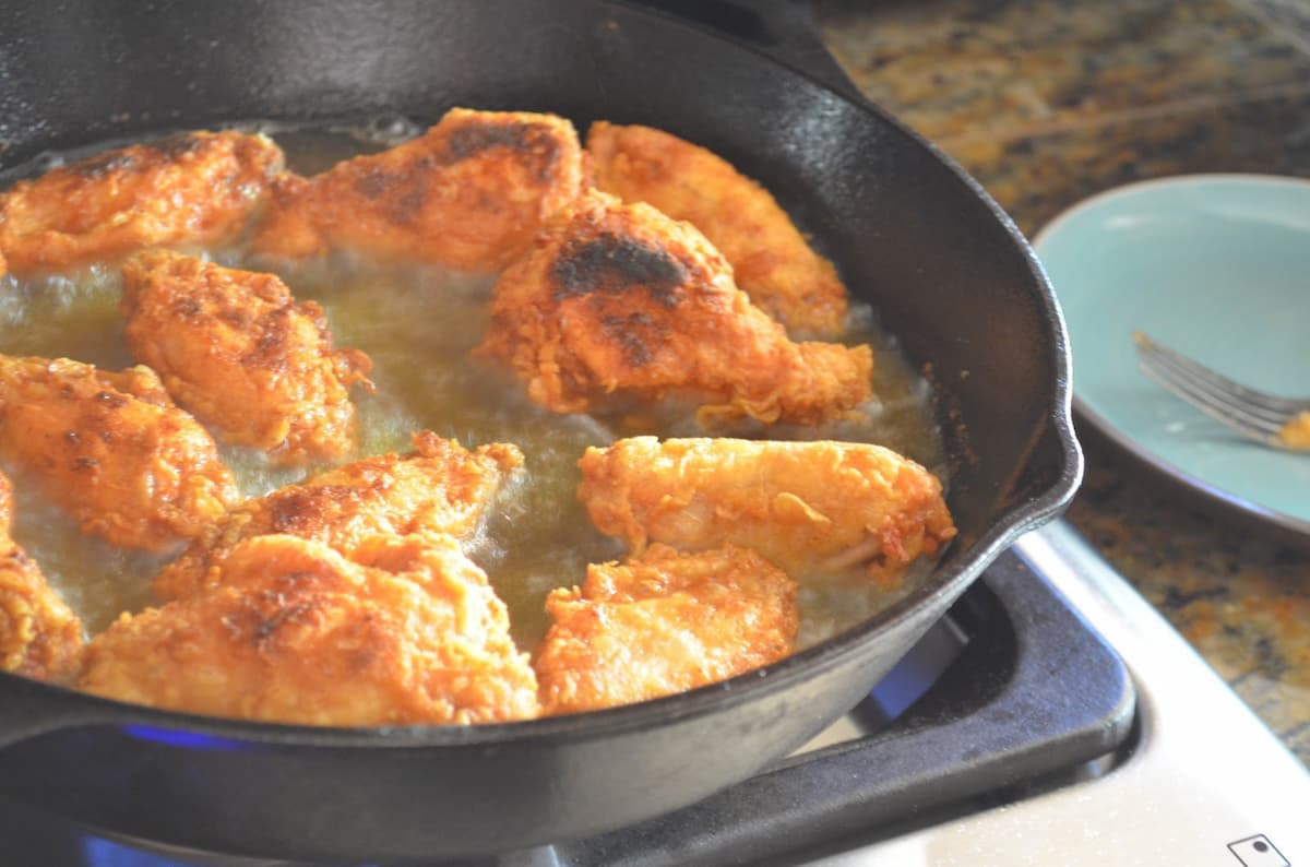Hot Wings Frying in a cast iron pan.