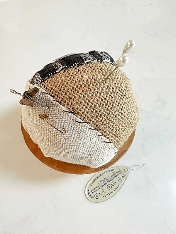 pin cushion with pins and a clothespin