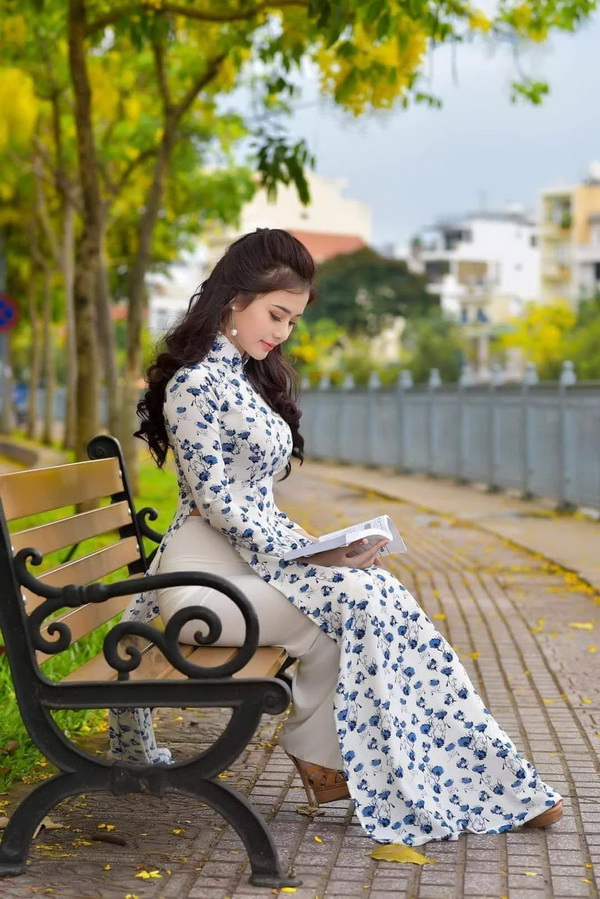 Thiếu nữ ngồi áo dài đọc sách