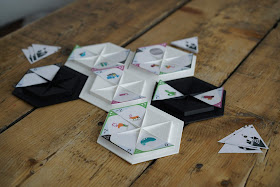 Plastic hexagons with insets where paper triangles with designs on them are placed.