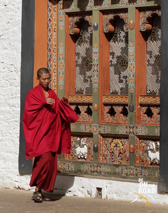 Buddhist Monk next to a colourful window at Punakha Dzong, Bhutan