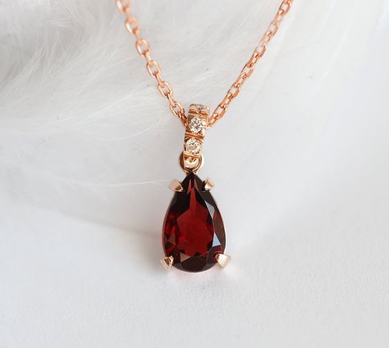 Gold necklace with garnet stone.