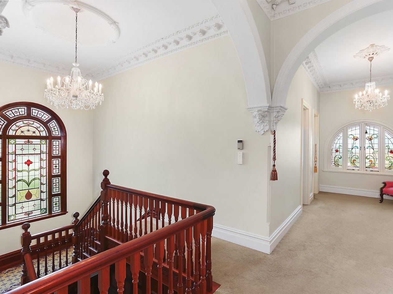 Stately staircase to upstairs foyer with Art Nouveau leadlight