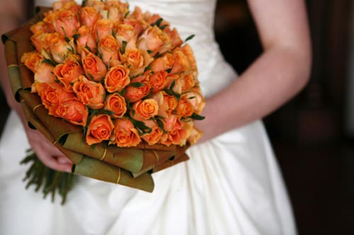 A bridal bouquet made up of beautiful orange roses can signify the burning 