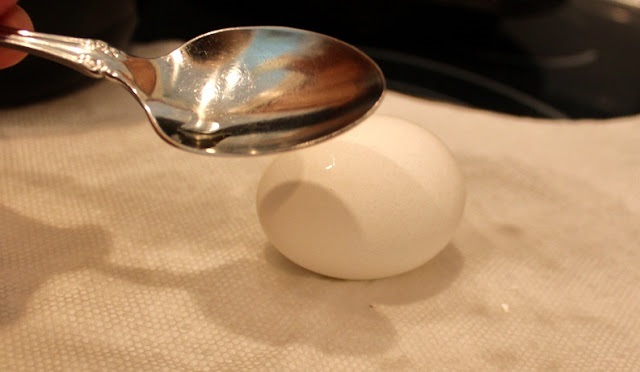 using a spoon to crack boiled eggs for Easter food art