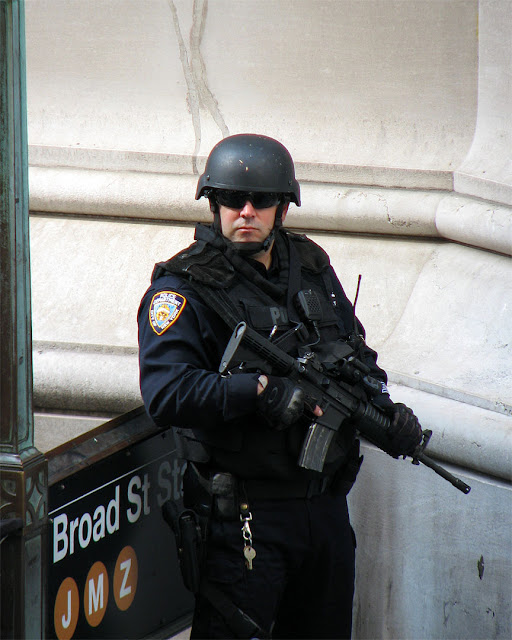 NYPD officer on guard, Broad Street at Wall Street, New York