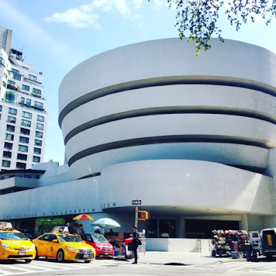 Guggenheim Museum in New York City with two yellow cabs in front