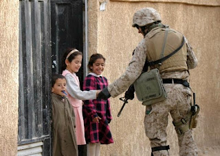 soldier gives something to small children