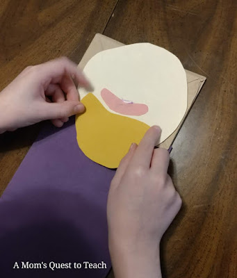 gluing on the construction paper beard onto the king paper bag puppet