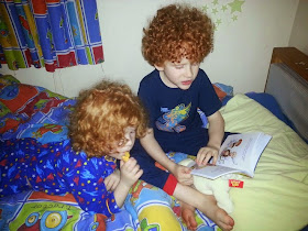 6 year old reading to his little brother in bed